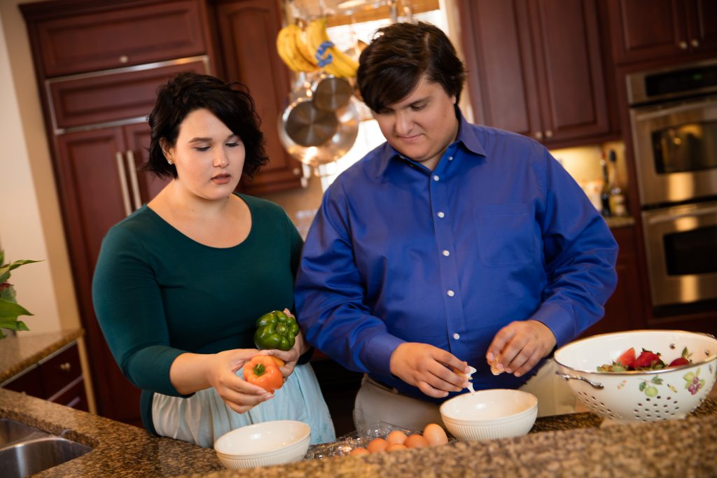 Young man and woman in the kitchen cooking